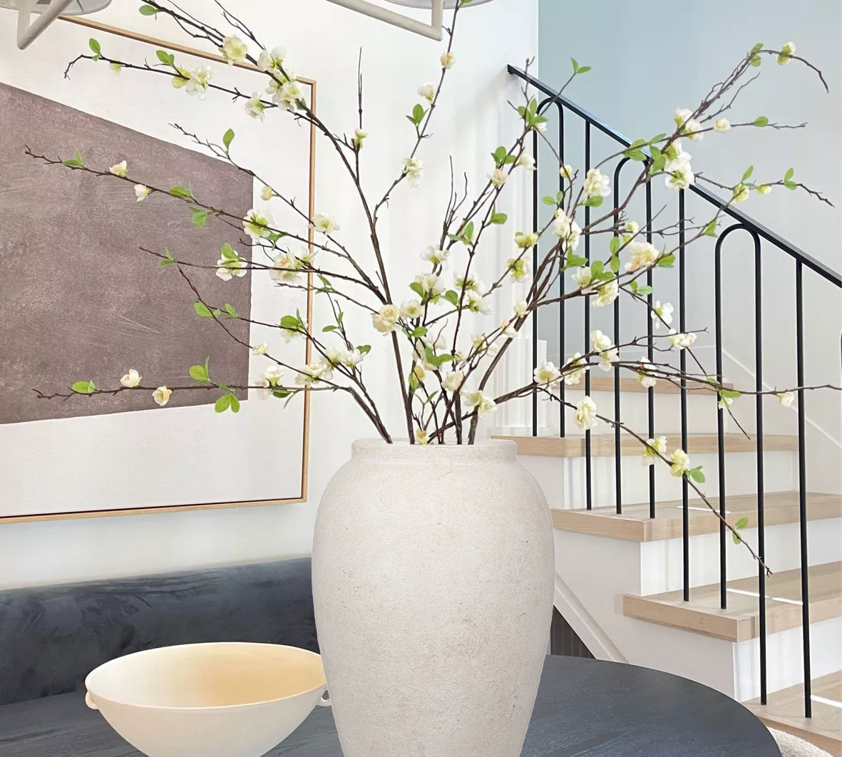 Scandinavian living room with faux olive branches in wooden vase