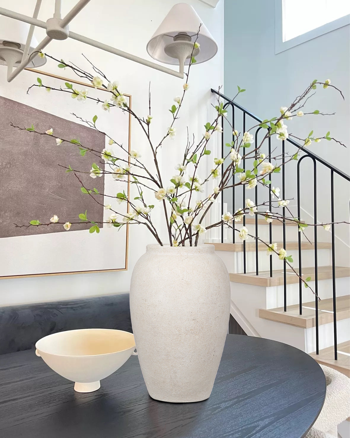 Scandinavian living room with faux olive branches in wooden vase